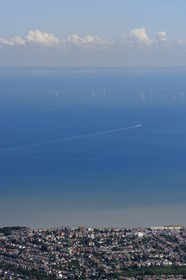United Kingdom, England, Kent, windmill generators field in the North Sea and the town of Whitstable (aerial view)