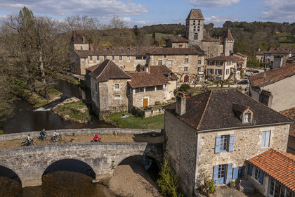 France, Dordogne (24), Périgord Vert, Saint-Jean-de-Côle, labellisé Les Plus Beaux Villages de France, cyclistes faisant la véloroute la Flow Vélo franchissant le pont médiéval du XIIème siècle, le clocher de l'église Saint-Jean-Baptiste (vue aérienne)