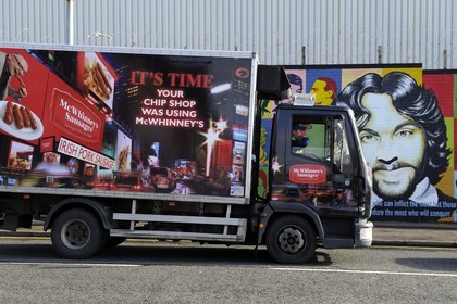 Royaume-Uni, Irlande du Nord, Belfast Ouest, le quartier catholique de Falls, International ou Solidarity Wall, peintures murales politiques sur Falls Road et fresque publicitaire pour des saucisses sur un camion de livraison