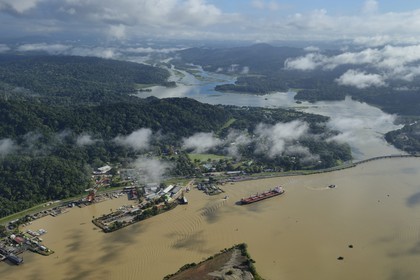 Panama, Panama Canal at Gamboa, the arm of the Chagres River which supplies the water to the canal and Gatun Lake, Panamax cargo and the Titan crane built by Nazi Germany on the left (aerial view)