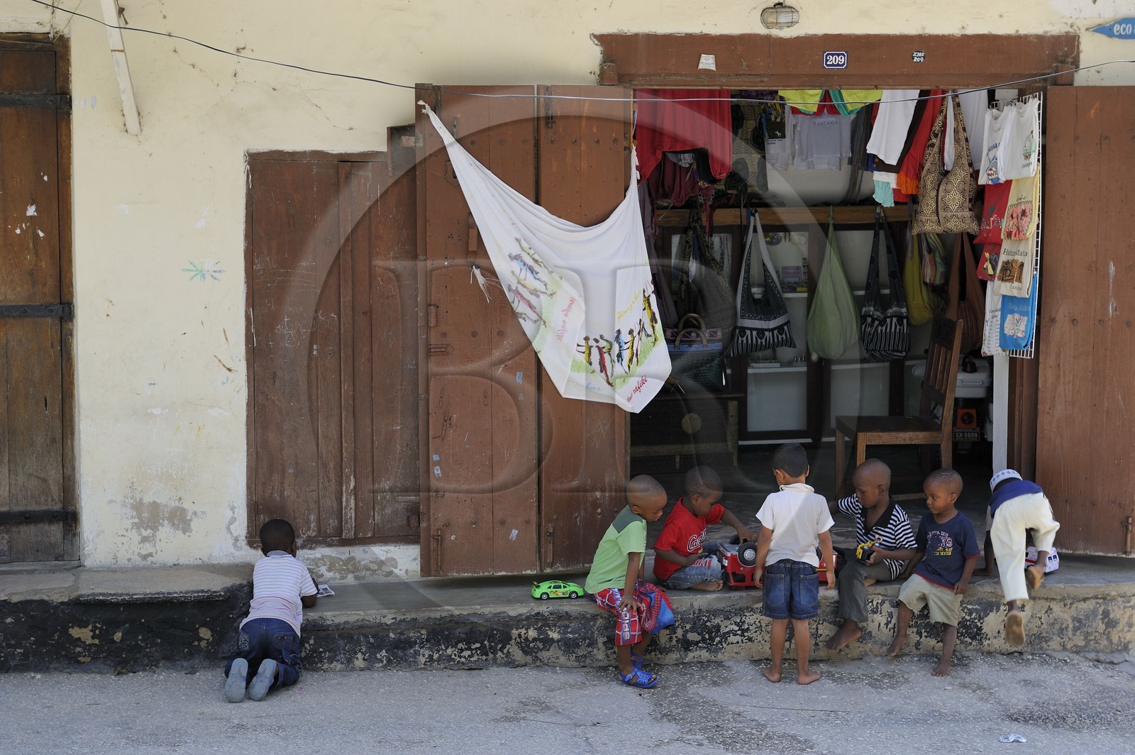 Tanzanie, archipel de Zanzibar, île de Unguja (Zanzibar), ville de Zanzibar, quartier Stone Town, classé Patrimoine Mondial de l' UNESCO, jeux d'enfants devant une boutique de la vieille ville dans le quartier de Shangani