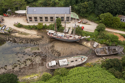 France, Finistère (29), Pays des Abers, Aber Wrac'h, Lannilis, le Moulin de l'Enfer, chantier naval de l'association AJD (association Amis de Jeudi-Dimanche) fondée par le Père Jaouen, l'épave de la goélette à trois mâts et hunier le Bel Espoir II à au premier plan et le nouveau Bel Espoir II à coque en acier derrière (vue aérienne)