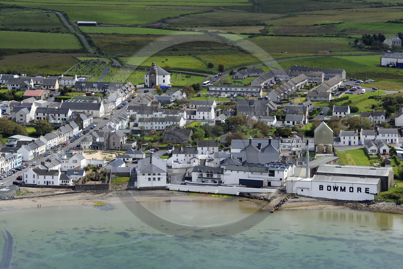 Royaume-Uni, Ecosse, Hébrides intérieures, Ile de Islay, Bowmore, la distillerie de whisky Bowmore sur la rive orientale du Loch Indaal et  la rue principale aboutissant à l'église ronde qui a été construit dans une forme circulaire pour empêcher le diable de se cacher dans un coin(vue aérienne)