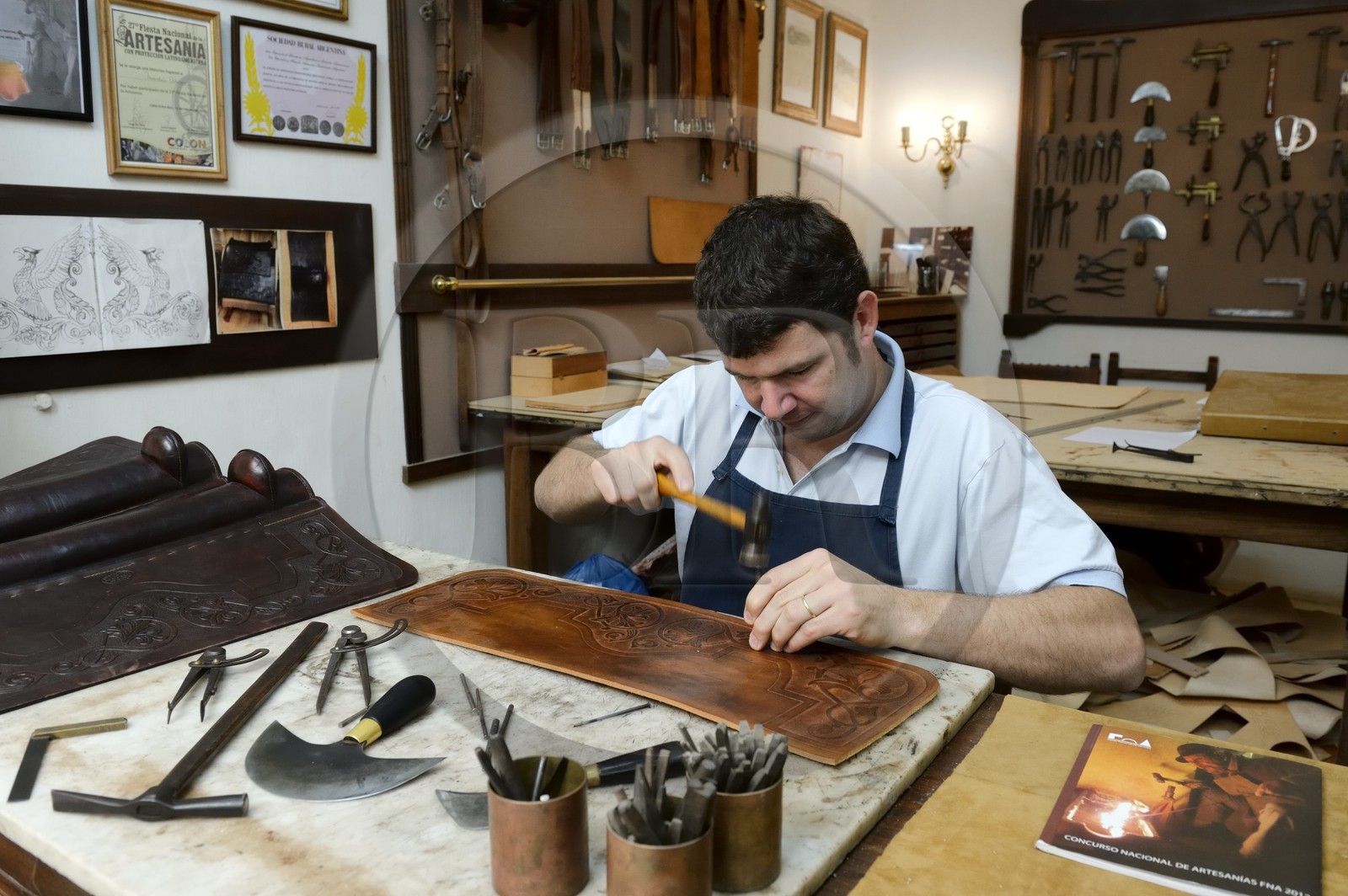 Argentine, province de Buenos Aires, San Antonio de Areco, atelier du maroquinier Martin Alvarez qui martèle le cuir d'un élément d'une selle
